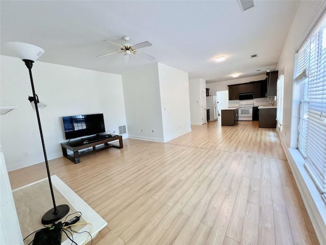 living room featuring ceiling fan and light hardwood / wood-style flooring