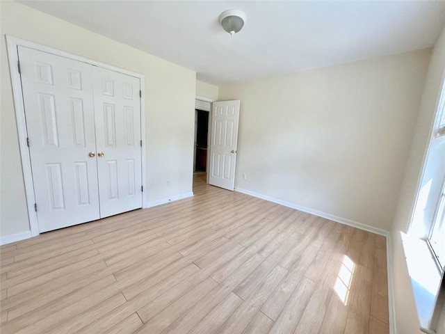 unfurnished bedroom featuring a closet and light hardwood / wood-style flooring