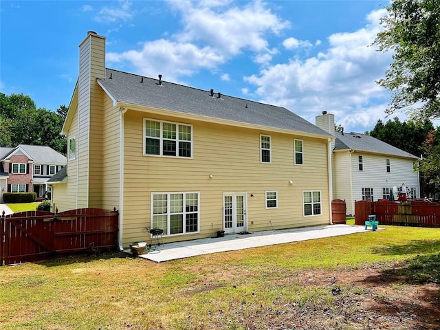 rear view of house with a yard and a patio