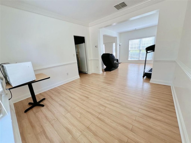 unfurnished office featuring light hardwood / wood-style floors and crown molding