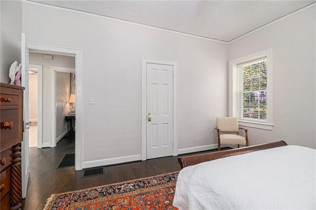 bedroom featuring wood finished floors, visible vents, and baseboards