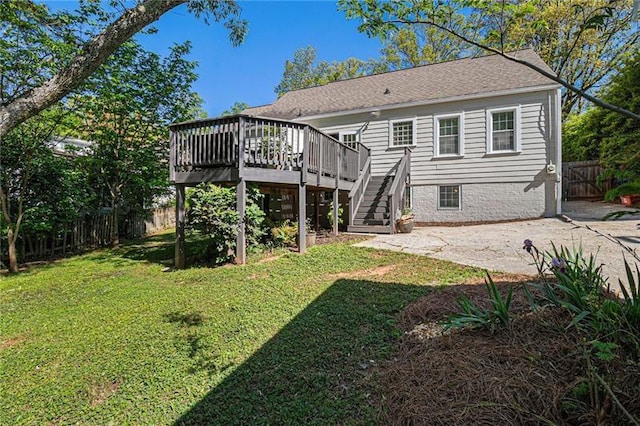 back of property featuring a fenced backyard, a yard, a deck, and stairs