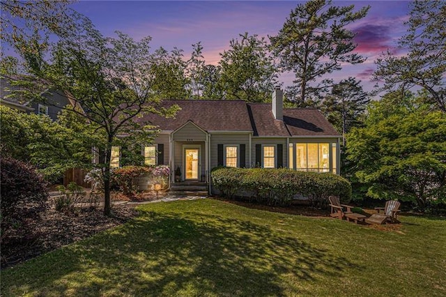 view of front of home with a yard and a chimney