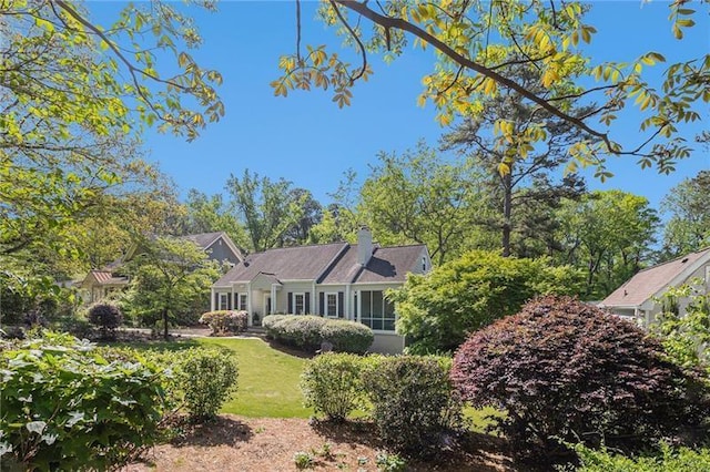 view of front of house featuring a chimney and a front yard