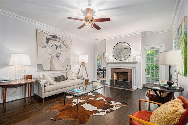 living area featuring ornamental molding, a premium fireplace, wood finished floors, and baseboards