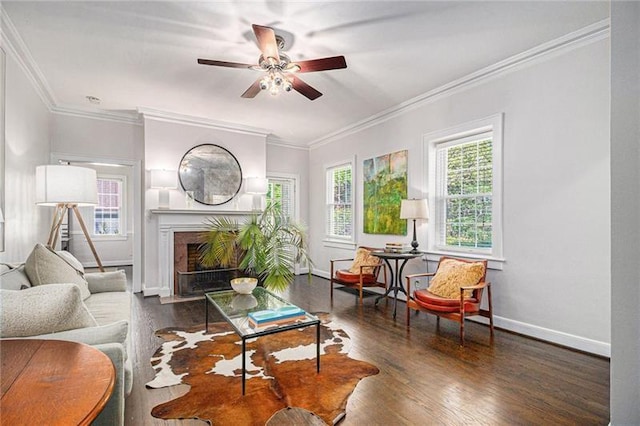 living room with ornamental molding, a premium fireplace, baseboards, and wood finished floors