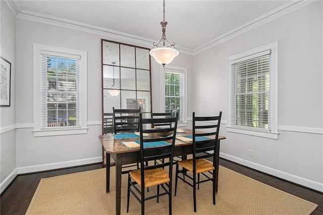 dining area with baseboards, wood finished floors, and crown molding