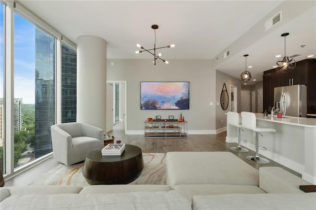 1080 Peachtree St NE Unit 1402, Atlanta, GA 30309 - living room with a chandelier, light wood-style floors, and baseboards