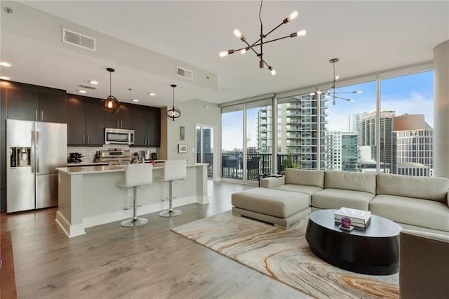 1080 Peachtree St NE Unit 1402, Atlanta, GA 30309 - living room with a chandelier, wood finished floors, a city view, baseboards, and recessed lighting
