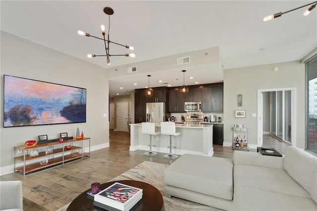 1080 Peachtree St NE Unit 1402, Atlanta, GA 30309 - living area with light wood finished floors, a chandelier, baseboards, and recessed lighting