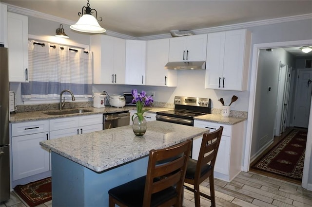 kitchen with light wood-style flooring, a sink, under cabinet range hood, white cabinetry, and stainless steel appliances