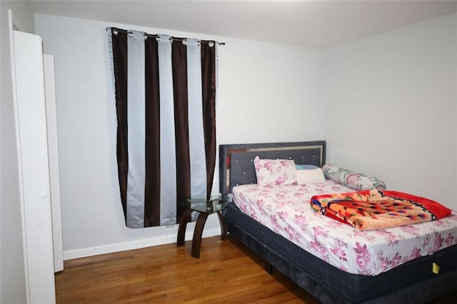 bedroom featuring wood finished floors and baseboards