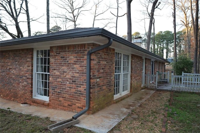 view of side of property with brick siding and a chimney