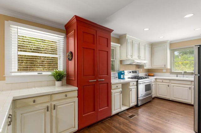 6596 Wright Rd NE, Atlanta, GA 30328 - kitchen featuring stainless steel gas range, under cabinet range hood, crown molding, tile counters, and a sink