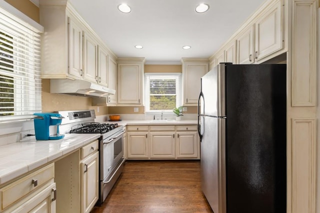 6596 Wright Rd NE, Atlanta, GA 30328 - kitchen with appliances with stainless steel finishes, under cabinet range hood, a sink, tile counters, and cream cabinets