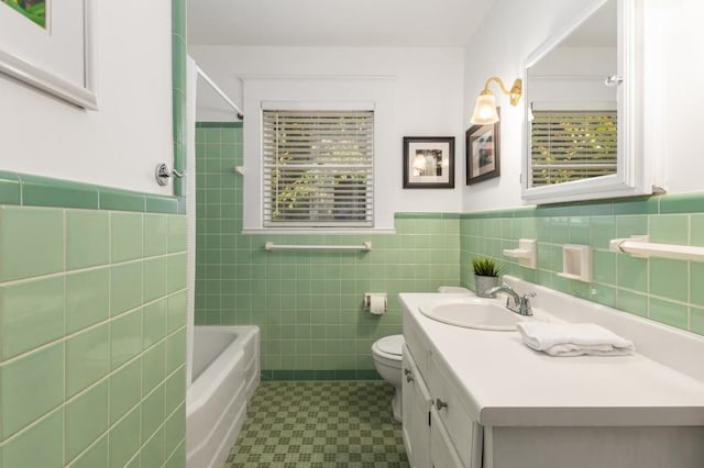 6596 Wright Rd NE, Atlanta, GA 30328 - full bathroom with tile walls, vanity, toilet, a wainscoted wall, and tile patterned floors