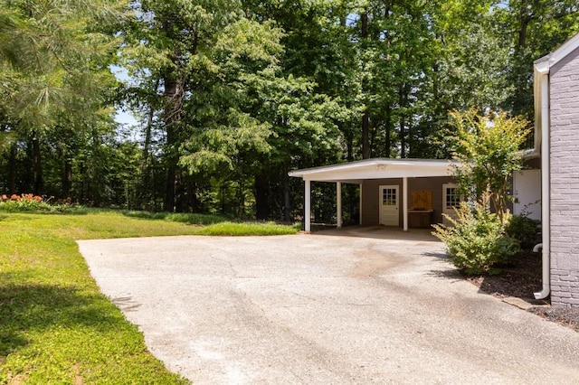 6596 Wright Rd NE, Atlanta, GA 30328 - view of grassy yard with asphalt driveway and an attached carport
