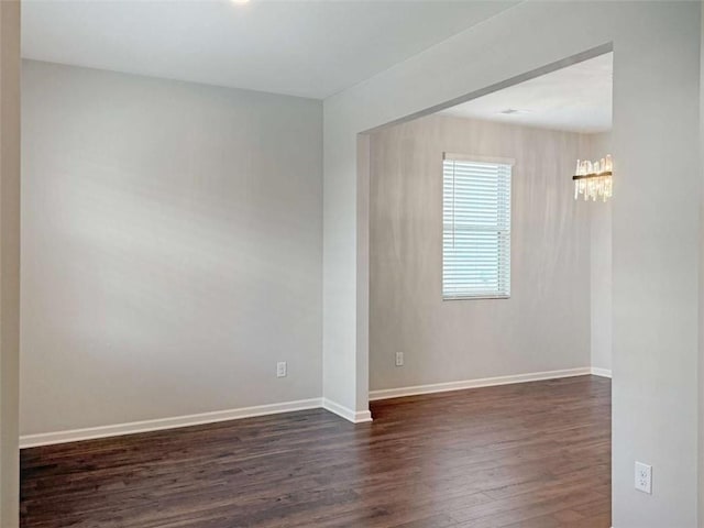3062 Hawthorn Farm Blvd, Loganville, GA 30052 - spare room featuring dark wood finished floors, a chandelier, and baseboards