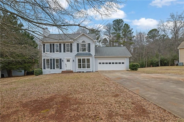 view of front of home with a garage, a front yard, and central air condition unit