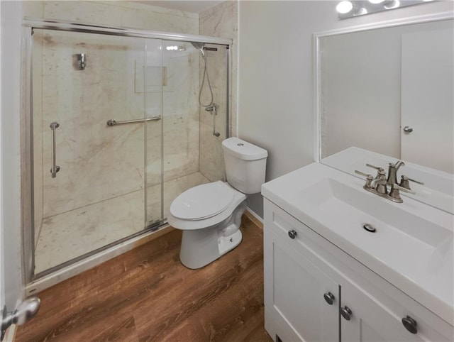 bathroom featuring a shower with shower door, toilet, hardwood / wood-style floors, and vanity