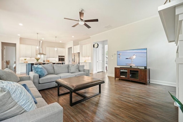 living room featuring ceiling fan, visible vents, dark wood finished floors, baseboards, and ornamental molding