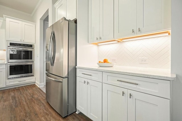 kitchen featuring crown molding, white cabinetry, tasteful backsplash, dark wood finished floors, and stainless steel appliances