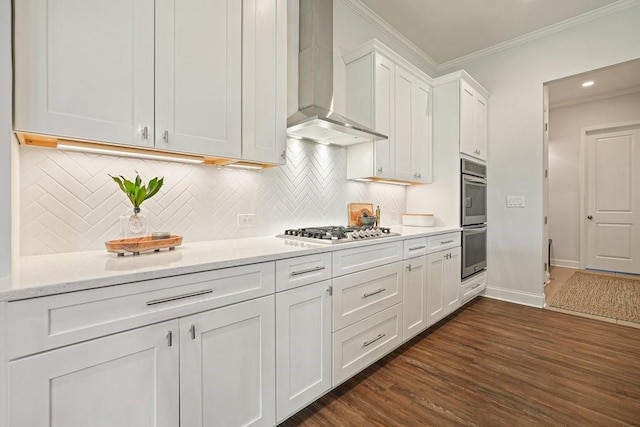 kitchen with crown molding, white cabinetry, dark wood-style floors, stainless steel appliances, and wall chimney exhaust hood