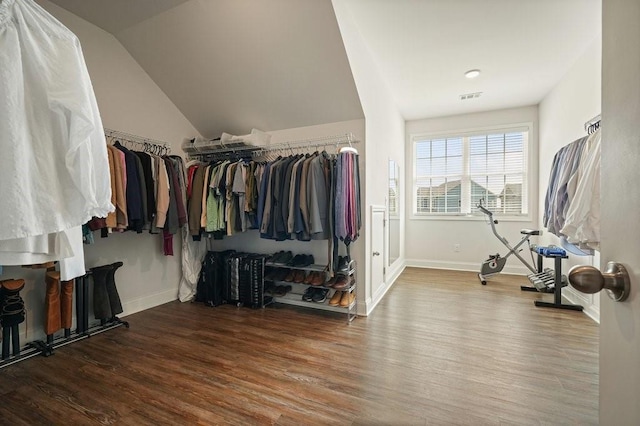 spacious closet with vaulted ceiling, wood finished floors, and visible vents