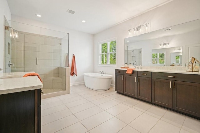 full bathroom with vanity, a freestanding tub, a stall shower, and a healthy amount of sunlight