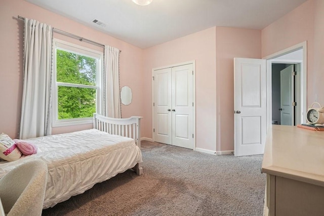 carpeted bedroom with baseboards, a closet, and visible vents