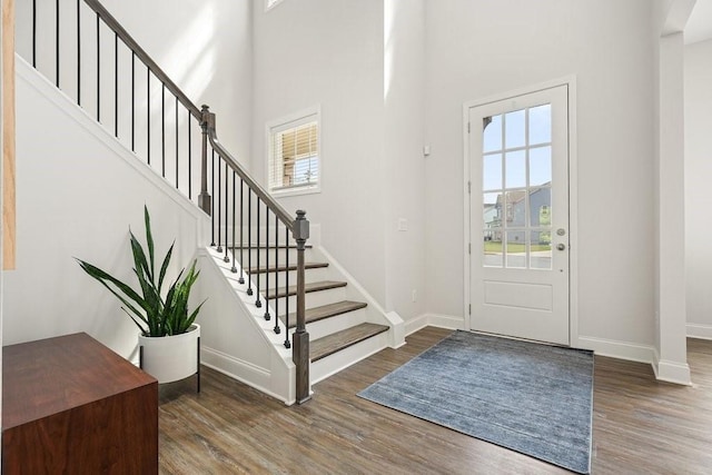 foyer entrance with a healthy amount of sunlight, baseboards, and wood finished floors