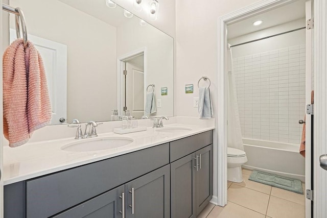 bathroom featuring tile patterned flooring, a sink, double vanity, and toilet