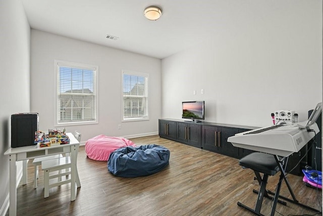 interior space with visible vents, baseboards, and wood finished floors