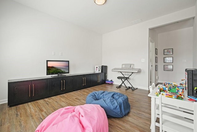 living area with baseboards and wood finished floors