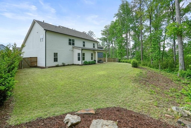 back of house with fence and a yard