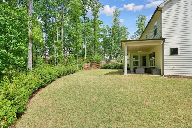 view of yard featuring fence, ceiling fan, and a patio area