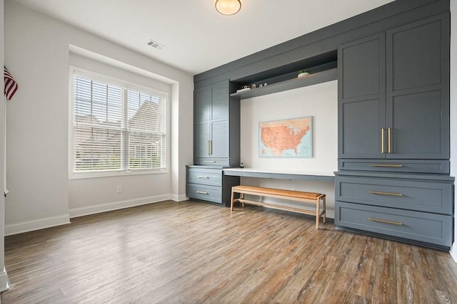 unfurnished bedroom with baseboards, visible vents, and wood finished floors