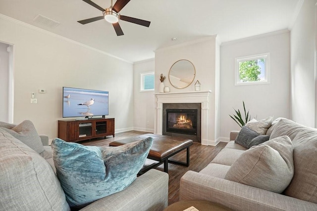 living room featuring ceiling fan, ornamental molding, wood finished floors, and plenty of natural light