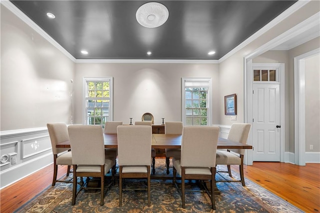 dining area featuring a wainscoted wall, plenty of natural light, and wood finished floors