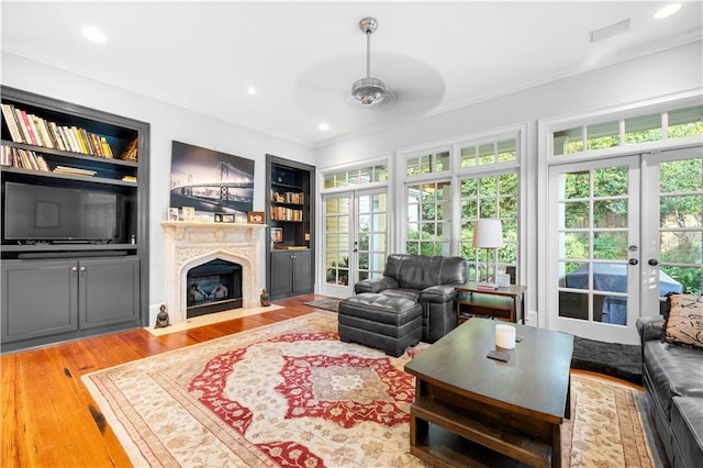 living room featuring french doors, ornamental molding, and plenty of natural light