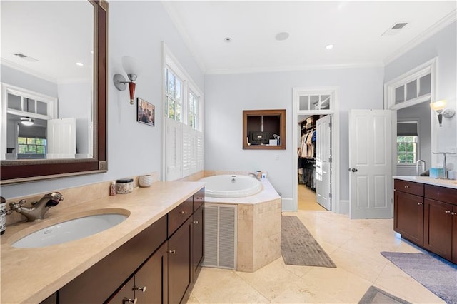 bathroom featuring tile patterned flooring, ornamental molding, tiled bath, and vanity