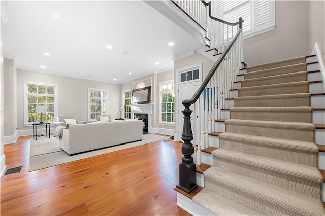 living room with stairs, ornamental molding, wood finished floors, and recessed lighting