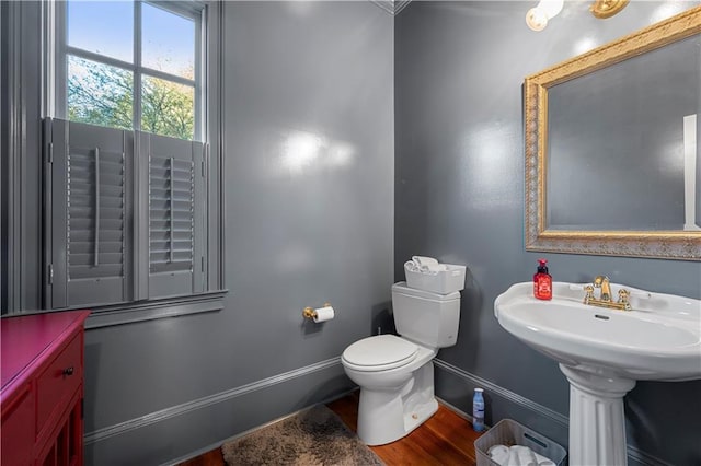 bathroom with baseboards, toilet, and wood finished floors