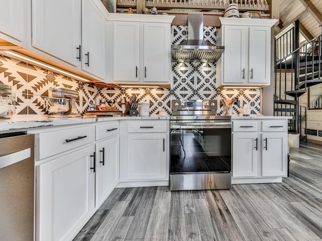 kitchen featuring dishwashing machine, electric range, wall chimney exhaust hood, and white cabinets