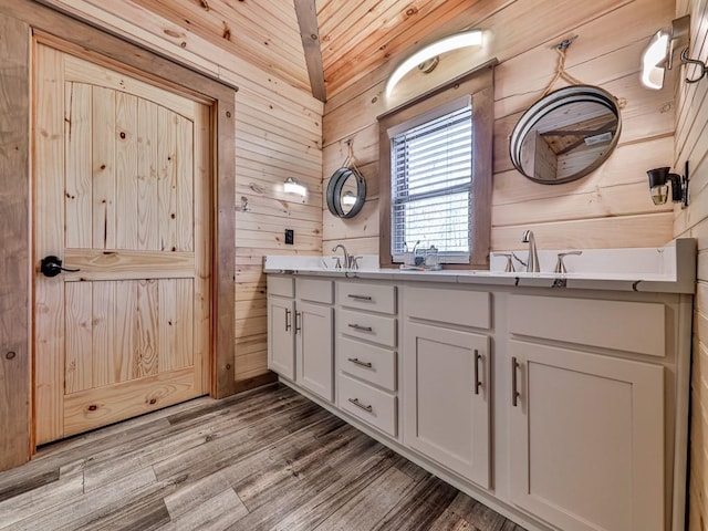 bathroom featuring hardwood / wood-style flooring, vanity, and wooden walls