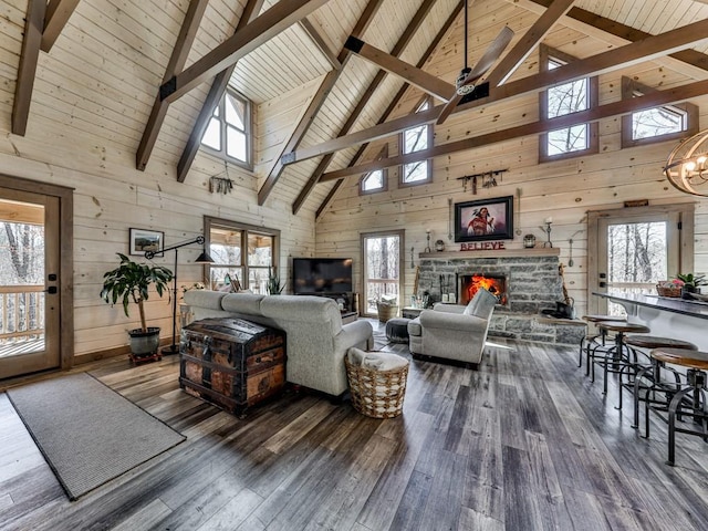 living room featuring hardwood / wood-style flooring, wooden walls, and a stone fireplace