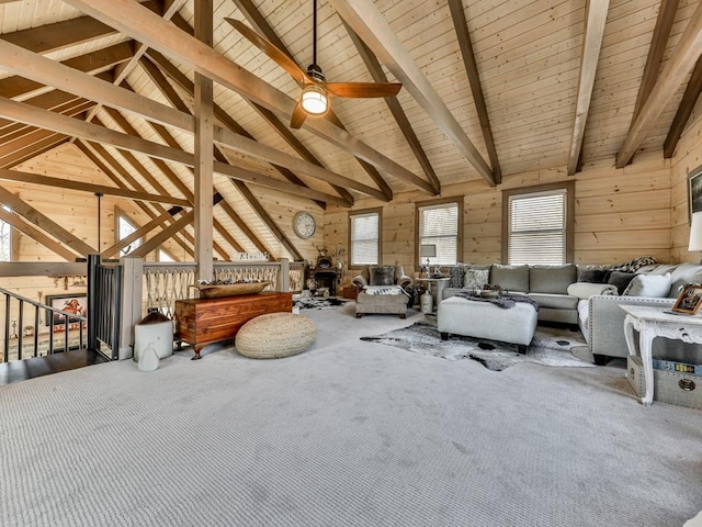 unfurnished living room featuring high vaulted ceiling, carpet floors, beam ceiling, and wood walls