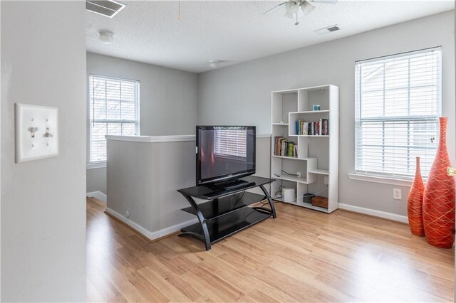 interior space with visible vents, baseboards, wood finished floors, and an upstairs landing