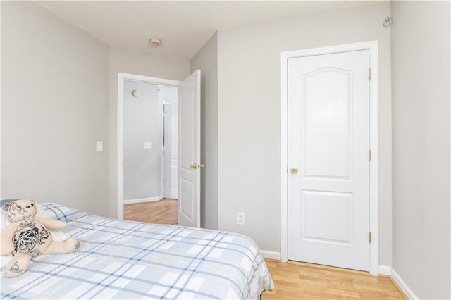 bedroom with light wood-style floors and baseboards
