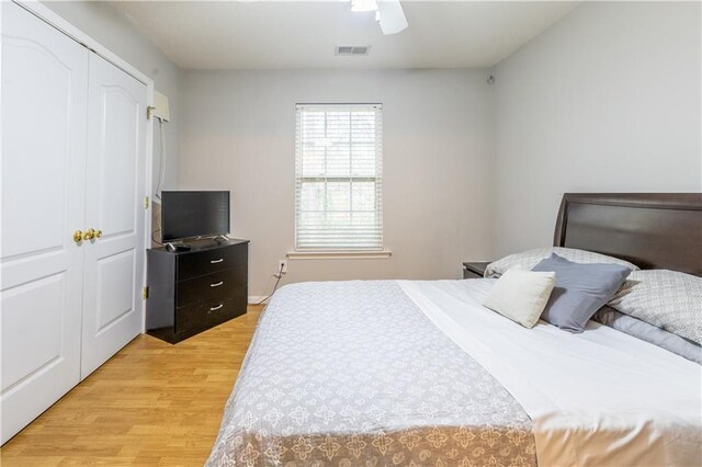 bedroom with a ceiling fan, visible vents, light wood-style flooring, and a closet